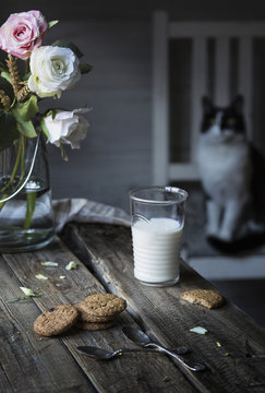 Glass of milk and cookies on wooden table