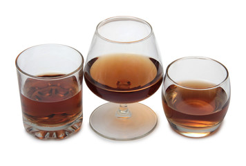 Glass jars with whiskey and ice on white background