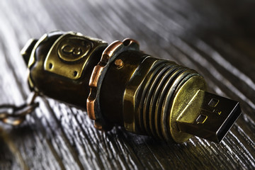 Macro image of vintage handmade steel USB drive at wooden background.