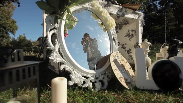 Cameraman working with camera outdoors, reflection in mirror