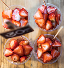 Ripe strawberries in a plastic cup. View from above.