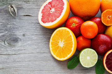 Naklejka na ściany i meble Lemon,red orange, orange, grapefruit, lime, tangerine on old wooden table. Place for text. Background.