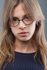 Fototapeta premium Fashion portrait of young elegant stylish girl with glasses with natural makeup. Pretty young sexy fashion sensual girl posing. Vogue style portrait.