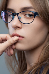 Fototapeta premium Closeup portrait of a young beautiful stylish girl with glasses with natural makeup. Vogue style portrait. 