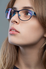 Young beautiful fashionable stylish girl with glasses with natural makeup. Vogue style portrait.