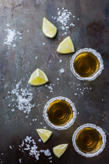 Golden mexican tequila shot with green lime and salt