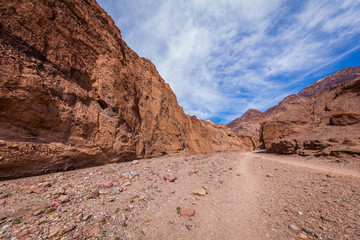 Fototapeta premium Narrow canyon with vertical walls on both sides. Rocky landscape background. Natural bridge canyon trail, Death Valley National Park, California