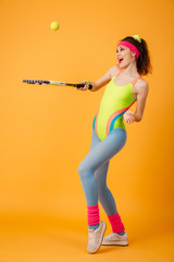 Happy joyful young sportswoman standing and playing tennis