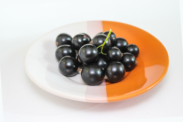 Large ripe berries of a black currant on a plate
