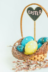 Happy Easter concept. Wicker basket full of colorful painted eggs on white background
