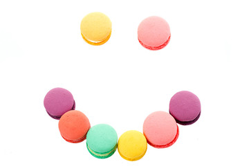 Smile from colourful macaroons on white background