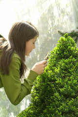 Girl looks through a magnifying glass plant