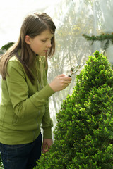 Girl looks through a magnifying glass plant