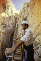 Obraz na płótnie Canvas adventurous man with helmet appreciating a cliff on a mountain expedition