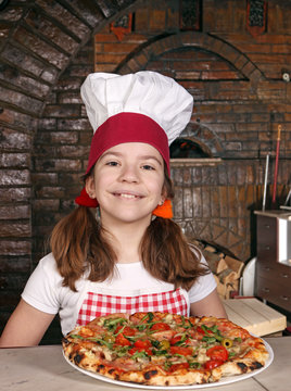 happy little girl cook with pizza in pizzeria
