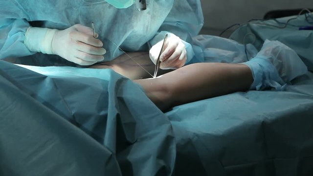 Surgeon stitching up during operation in operating room