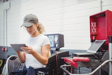 Female mechanic using digital tablet