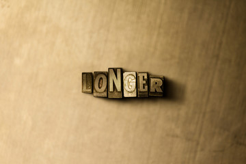 LONGER - close-up of grungy vintage typeset word on metal backdrop. Royalty free stock illustration.  Can be used for online banner ads and direct mail.