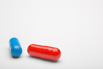 Two medical pills blue and red with shadows