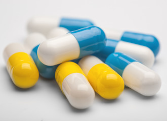 pile of medical pills and blue pills on a background