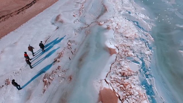 Winter landscape. Frozen sea. People go on the ice
