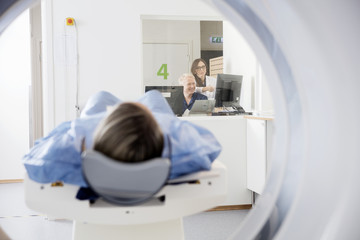 Doctor's Using Computers While Patient Undergoing CT Scan