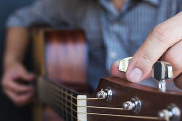 Man tuning acoustic guitar