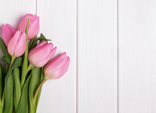 Pink tulips on wooden table