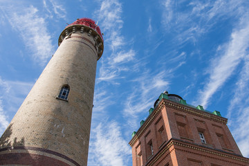 The two lighthouses at Cape Arkona on the island of Rügen in the Baltic Sea against a blue sky with clouds