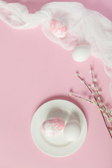 White Easter eggs on white plate on a light pink background