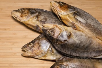 Salty dry river fish to beer on a wooden table. Macro shot.