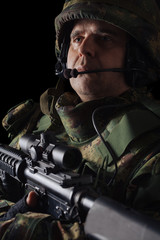 Special forces soldier with rifle on dark background