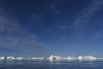 many icebergs on the bottom and a blue sky on top with place for your ideas