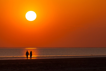 Fototapeta premium Liebes Paar beim Sonnenuntergang am Strand