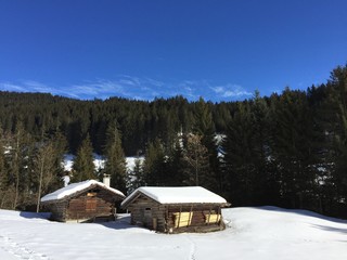 Bergh&uuml;tten im Schnee mit blauem Himmel in Beatenberg - Schweiz