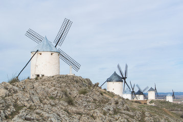 White old windmills on the hill near Consuegra (Castilla La Mancha, Spain), a symbol of region and journeys of Don Quixote (Alonso Quijano) on cloudy day.