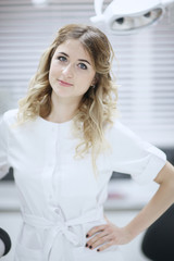 Portrait of a female doctor standing near a drill at the dental clinic