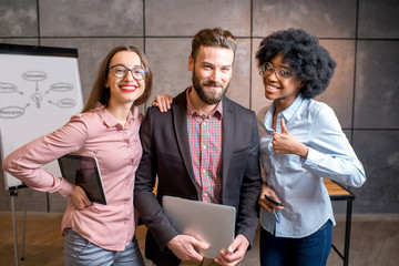 Portrait of three happy multi ethnic coworkers together at the office