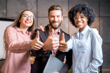 Portrait of three happy multi ethnic coworkers together at the office