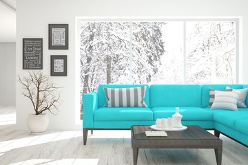 White room with sofa and winter landscape in window. Scandinavian interior design