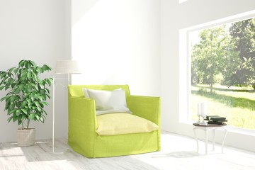 White room with armchair and green landscape in window. Scandinavian interior design