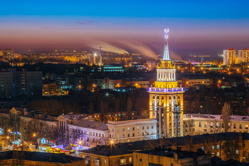Fototapeta na wymiar Night cityscape of Voronezh, view from rooftop of skyscraper, Tower in architecture Stalinist empire with star illuminated by colored lights