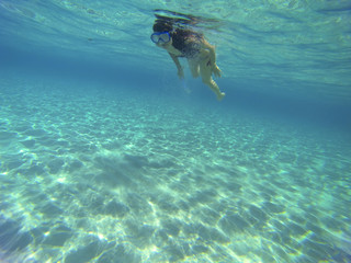 Fototapeta na wymiar incredible turquoise water with a young woman scuba diving with a snorkel isolated under the sea
