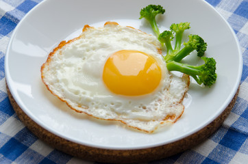 Scrambled eggs served on a platter with broccoli