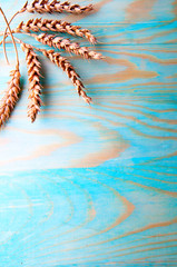 Wheat ears on wooden background, copyspace