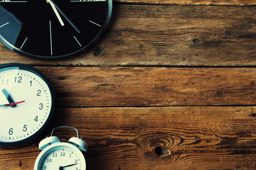 Many different clocks on wooden table, copyspace