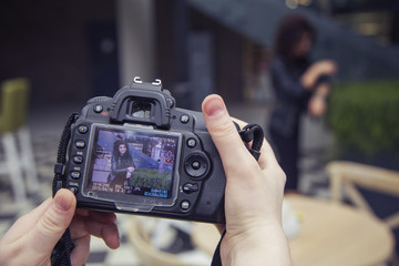 Photographer shooting a beautiful brunette woman on a walk on european city street in daylight. outdoors