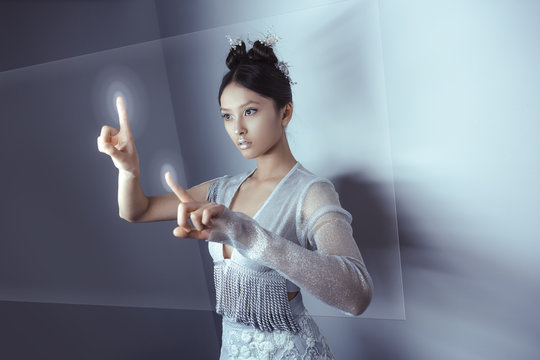 Future concept. Young pretty asian woman touching digital hologram