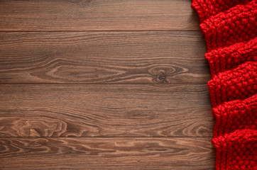 Knitted red blanket on a wooden background with copy space