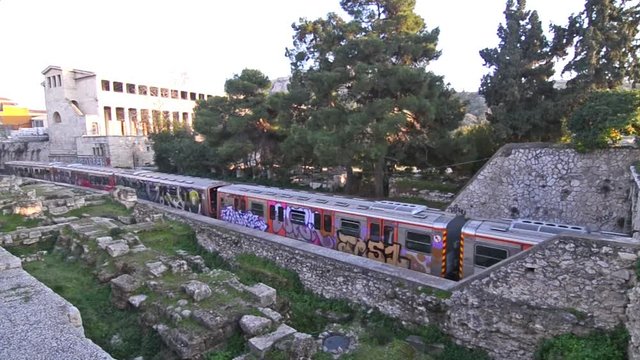 train passing from Thisio Athens Greece and the ancient Stoa of Attalos behind